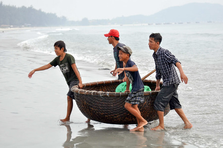 Nha Trang, VIETNAM - SEPTEMBER 30,2013: Vietnamese fishermen with the national boat "Dong"のeditorial素材