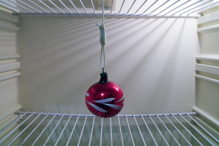 red christmas ball hung in the empty refrigeratorの写真素材