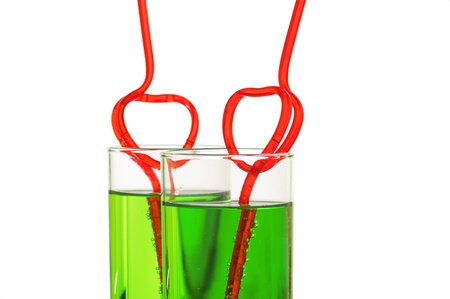 two glasses with green beverage and drinking strawsの写真素材