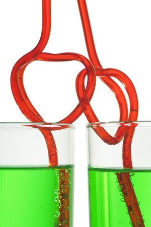 two glasses with green beverage and drinking strawsの写真素材