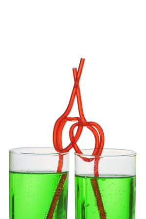 two glasses with green beverage and drinking strawsの写真素材