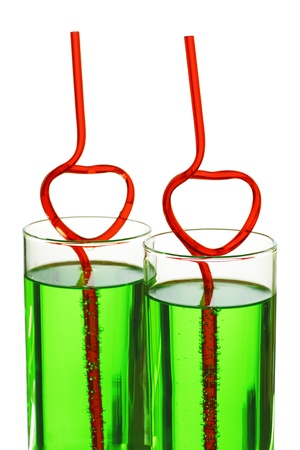 two glasses with green beverage and drinking strawsの写真素材