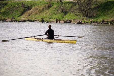 man floats on a yellow canoe down the riverの写真素材