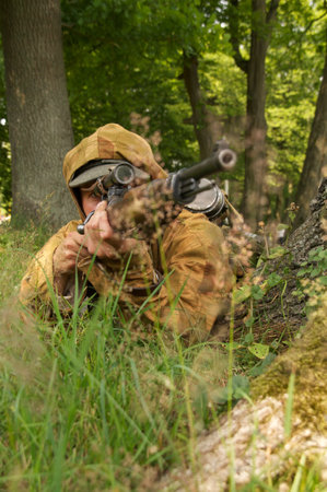 man in form of nazi sniper aims near a tree on celebration of 750 anniversary of Guryevsk (Neuhausen O.P.) on June 30, 2012 in Guryevsk, Kaliningradskaya oblast, Russiaのeditorial素材
