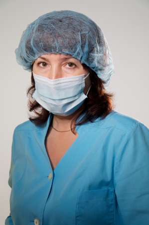 serious woman looks at camera in medical maskの写真素材