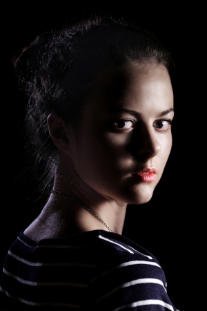 girl looking back on black backgroundの写真素材