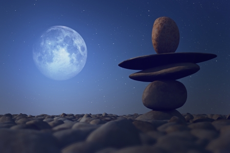 stacked stones in moonlight on pebble sea beachの写真素材