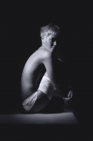 naked blond girl in white panties and stockings sitting on dark backgroundの写真素材