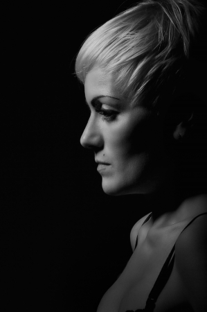 serious woman profile in the dark background monochrome imageの写真素材