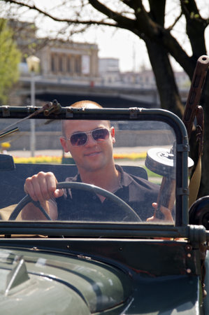 Kaliningrad, Russia - May 05, 2013 - man in sunglasses posing with vintage machine gun in military jeepのeditorial素材
