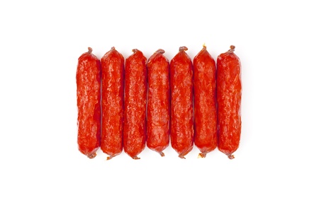 small smoked sausages stacked at a white backgroundの写真素材