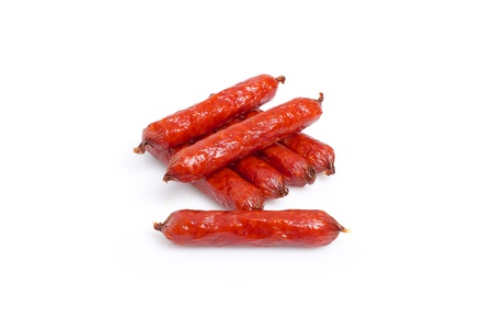 small smoked sausages stacked at a white backgroundの写真素材