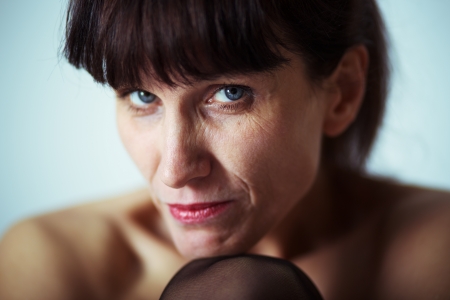 seriouse mature woman with bared shoulders looking at cameraの写真素材