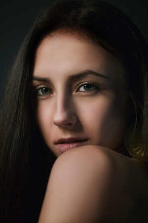 sensual girl looking over shoulder in darkの写真素材