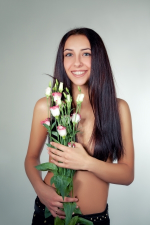 laughing bare girl with flowers looks at cameraの写真素材