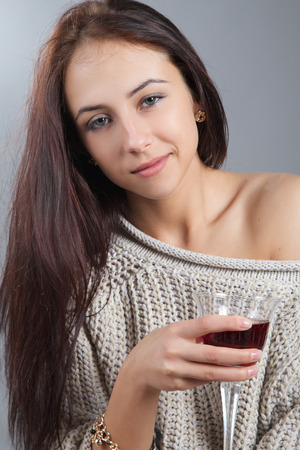 pretty sad girl with wine glass looking at cameraの写真素材