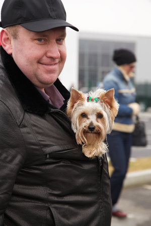 KALININGRAD, RUSSIA â MARCH 02, 2014: Man put a dog in a jacket and smiled on the streetのeditorial素材