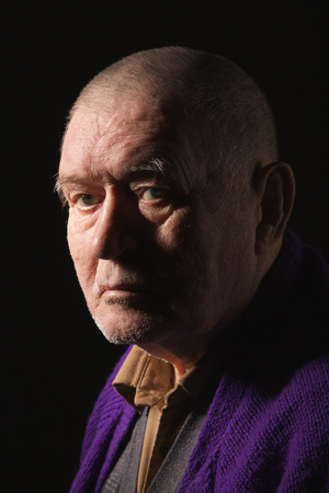 serious old man senior on black background looking at cameraの写真素材