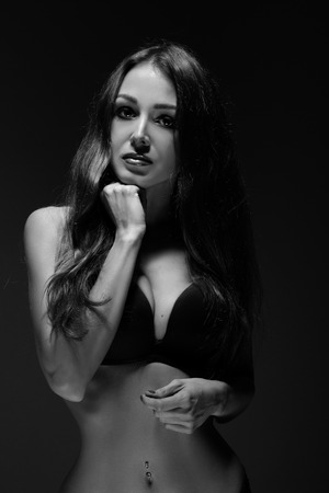 sad luxury girl in black lingerie on dark monochrome imageの写真素材