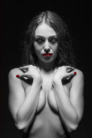 luxury young woman covering her body with closed eyes monochrome image with color effectsの写真素材