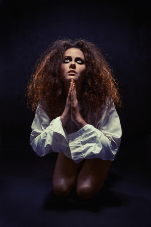 woman praying on knees ar darkの写真素材