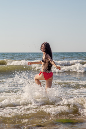 pretty slim girl jumping in sea surfの写真素材