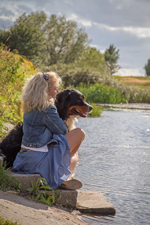 woman with her dog near summer pondの写真素材