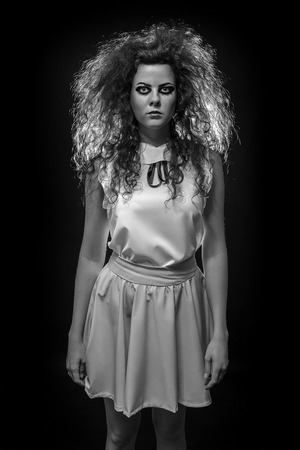 serious crazy woman with fluffy hair looking at camera, monochrome imageの写真素材