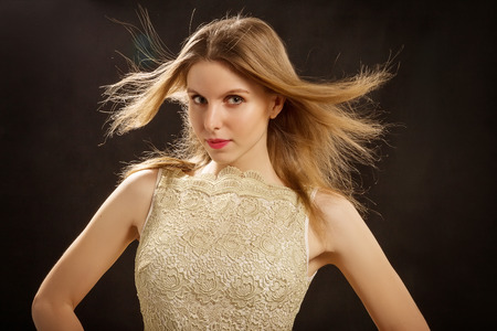 Beautiful woman with a flying hair on a black backgroundの写真素材