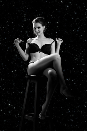 girl in lingerie sitting in light rays on starsの写真素材