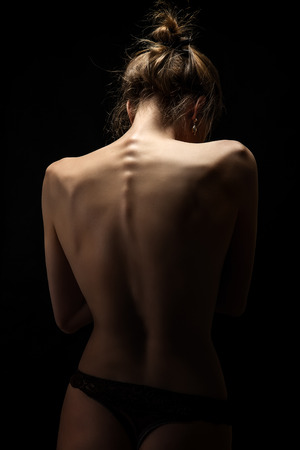 naked female tanned back on black backgroundの写真素材