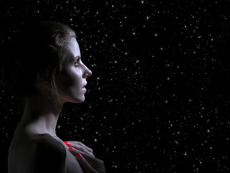 sad female profile on stars sky background, toned image