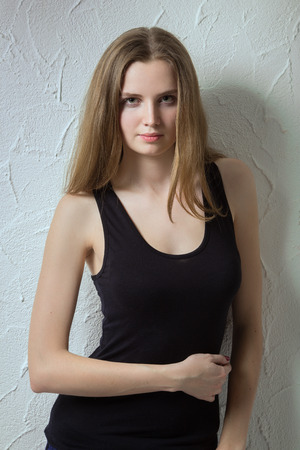 beautiful young woman standing near wallの写真素材
