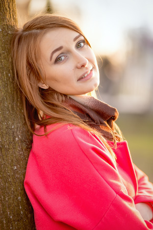 sensual woman with red hair relax near treeの写真素材