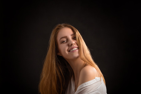 happy smiling blond girl on black backgroundの写真素材