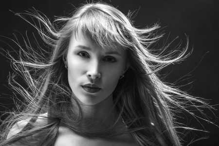young woman with flying hair on blackの写真素材