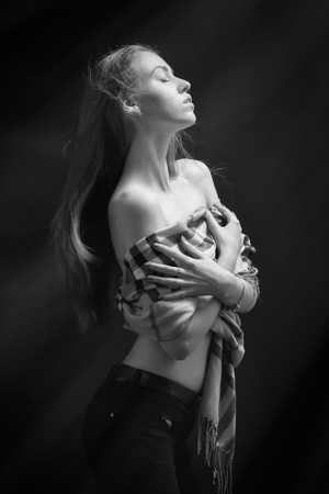 sensual girl with bared shoulders in light rays monochromeの写真素材