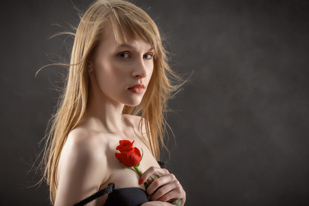 sensual girl with long hair and red rose on blackの写真素材