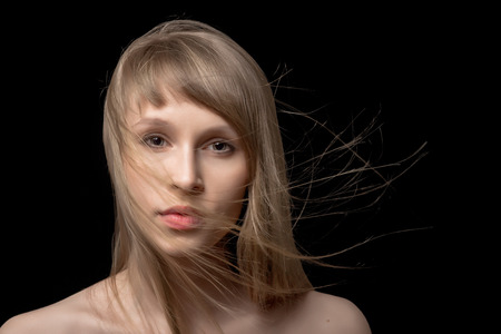 young woman with flying hair on blackの写真素材