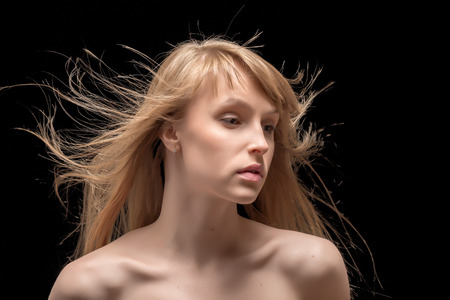 young woman with flying hair on blackの写真素材