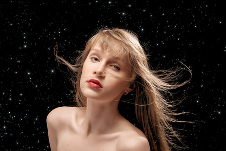 luxury naked woman with flying hair on stars sky backgroundの写真素材