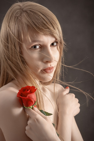 sensual girl with long hair and red rose on blackの写真素材