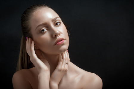 beautiful young woman portrait on black backgroundの写真素材