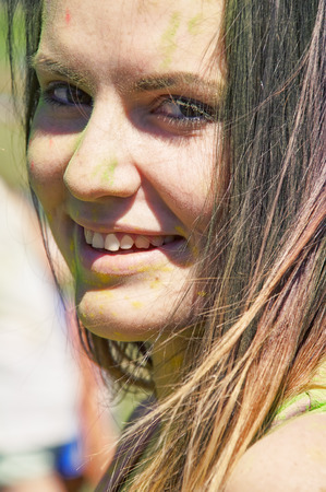 happy girl with multicolor paint on faceの写真素材