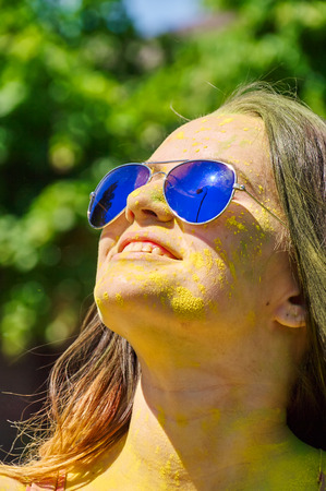 girl with multicolored face and sunglasses at Holi Festivalの写真素材