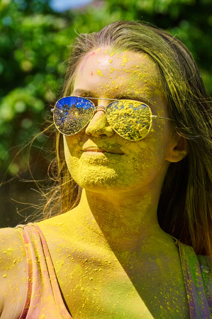 girl with multicolored face and sunglasses at Holi Festivalの写真素材