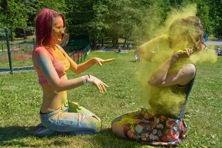 KALININGRAD, RUSSIA - JUNE 06, 2015: Woman throwing yellow holi powder at camera during the Holi Festival of Colors. Holi is a festival celebrated as a festival of coloursのeditorial素材