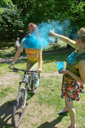 KALININGRAD, RUSSIA - JUNE 06, 2015: Woman throwing cyan holi powder at camera during the Holi Festival of Colors. Holi is a festival celebrated as a festival of coloursのeditorial素材