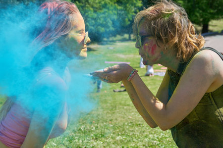 KALININGRAD, RUSSIA - JUNE 06, 2015: Woman blowing cyan holi powder during the Holi Festival of Colors. Holi is a festival celebrated as a festival of coloursのeditorial素材