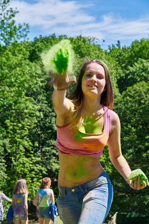 KALININGRAD, RUSSIA - JUNE 06, 2015: Woman throwing green holi powder at camera during the Holi Festival of Colors. Holi is a festival celebrated as a festival of coloursのeditorial素材